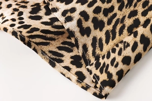 Close-up of leopard print chiffon fabric featuring detailed stitching and hem finish