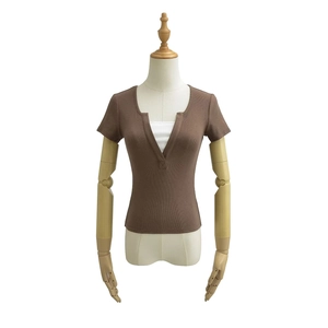 Détail du haut en maille côtelée à col en V avec un design contrasté marron et blanc