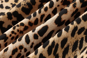 Macro detail of leopard print midi skirt fabric showing lightweight polyester texture