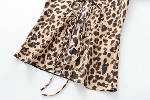Detail of leopard print satin fabric with decorative front bow tie and lace-up design