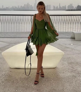 Detail of dark green off-shoulder dress with slit sleeves and tassel drawstring waist