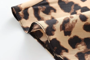 Close-up detail showing classic leopard print pattern and precise stitching on silk satin shirt