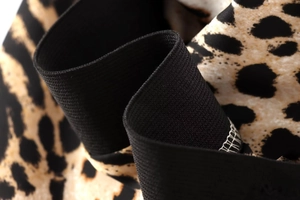 Detailed macro shot of the black elastic waistband and leopard print midi skirt fabric
