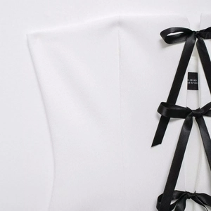 White off-shoulder summer top with black bow ribbon tie detail and smooth fabric texture
