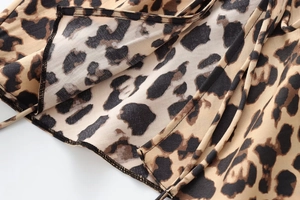 Close-up of leopard print satin blouse fabric showing clean stitched hem and texture