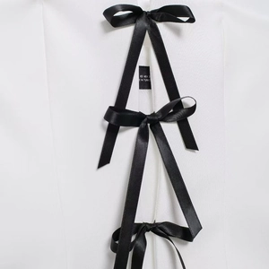 White off-shoulder top with black satin bow lace-up details and Turkey label