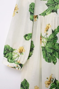 Close-up of vibrant floral print and sleeve stitching on white summer dress fabric