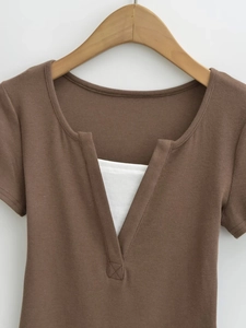 Détail du crop top en maille côtelée marron avec col en V et empiècement blanc