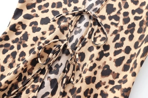 Close-up of leopard print satin shirt featuring elegant front bow-tie ribbon closures