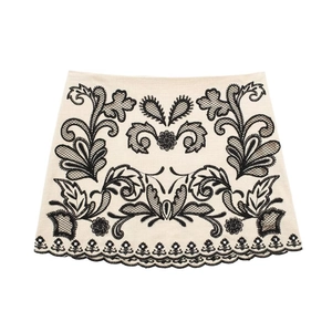 Beige two-piece mini skirt set with black floral embroidery and scalloped hem