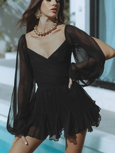 Detailed view of the V-neckline and sheer lantern sleeves on a chic black mini dress