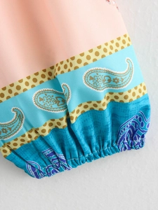Dettaglio ravvicinato dei polsini elastici con stampe paisley e motivi geometrici
