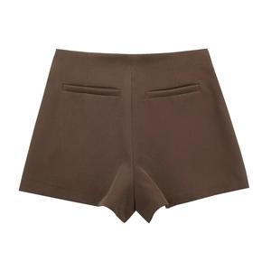 Detail of high waist brown shorts featuring minimalist back welt pockets and smooth fabric
