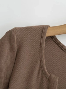Détail de la texture en maille côtelée marron et des coutures de finition sur le vêtement