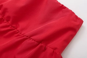 Detail of red elastic waistband showing fine stitching and pleated fabric texture
