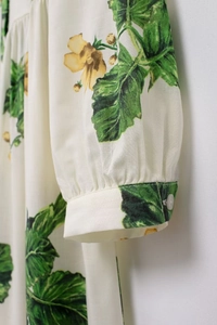 Detailed close-up of floral print sleeve with smocked cuff and transparent button