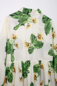 Detailed back view of white floral print shirt with green leaves and yellow blossoms