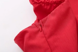 Detailed macro view of the seamless invisible side zipper on a red slim-fit cropped top