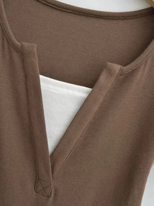 Détail du haut court en maille côtelée bicolore marron et blanc avec col en V