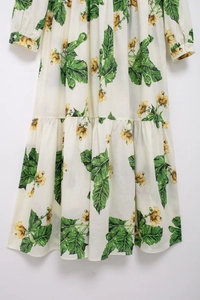 Detail showing realistic green leaves and yellow floral print on layered tiered dress fabric