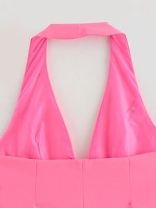Close-up of bright pink halter neck top showing smooth satin fabric and deep V-neckline