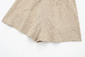 Detailed view of floral embroidery on beige cotton-linen summer casual shorts