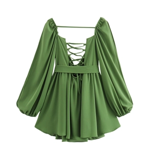 Detailed back view of green V-neck dress featuring lace-up cutout and lantern sleeves