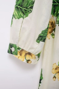 Close-up of sleeve cuff with sunflower print and white button on summer dress