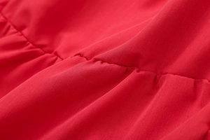 Macro view of red cotton blend fabric with ruched stitching detail for summer top