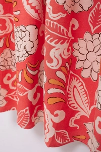 Close-up detail of coral pink floral print fabric with high-quality textile texture