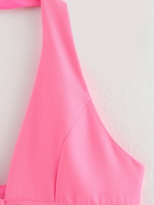 Detail shot of neon pink halter neck top showing fine horizontal woven fabric texture