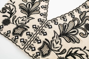 Detail of bohemian halter top with black embroidery and mirror sequins on beige fabric