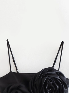 Detail of black satin camisole featuring a large 3D fabric rose and adjustable straps