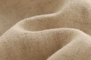 Makroaufnahme von natürlichem Leinenstoff mit atmungsaktivem Gewebe und beige Faserstruktur