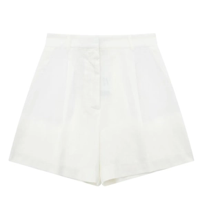 Detail of high-waisted white woven linen shorts featuring front pleats and belt loops
