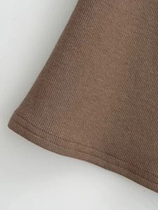 Gros plan détaillé du tissu en maille côtelée marron avec couture à double aiguille