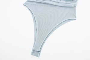 Close-up of light blue mesh bodysuit featuring pleated texture and seamless bottom hem
