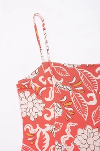 Close-up of coral red dress with tropical floral print and invisible zipper detail