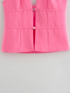 Detail of rose pink corset top featuring silver metal buckles and refined stitching