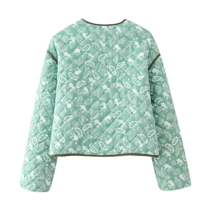 Detail of mint green quilted jacket featuring paisley print and green edge binding