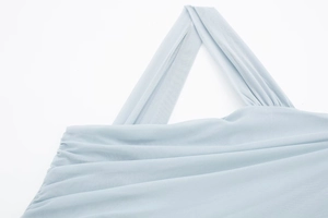 Detailed close-up of light blue mesh fabric with asymmetric pleats and fine texture