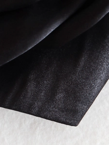 Macro detail of high-quality black embossed floral fabric with elegant twill texture