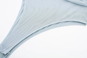 Detail of light blue mesh bodysuit showing fine stitching and snap button closure