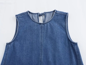 Detail of light blue denim dress showing round neck and back tie-up closure design