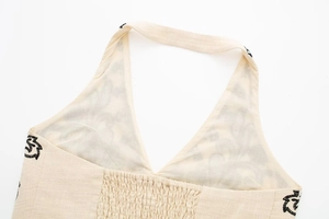 Detail of embroidered halter top with elastic smocked back and floral print patterns