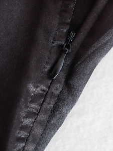 Detailed macro view of high-quality invisible zipper and smooth black satin fabric texture