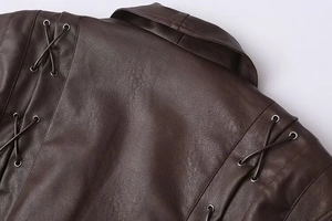 Detail of dark brown faux leather jacket featuring lace-up shoulder with silver eyelets