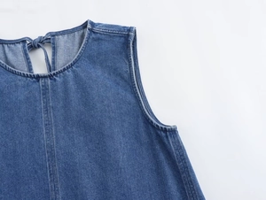 Detail of light blue denim dress showing round neck and lace-up back closure