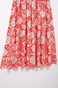 Close-up of floral print pattern on orange summer dress fabric with soft natural drapes