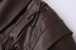 Detailed macro view of dark brown faux leather jacket with metal eyelets and cross laces